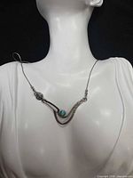 Necklace displayed on bust showing pendant design and chain