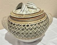 Full view of stoneware pot with lid showing handles and lattice pattern