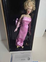 Doll in box with COA and stand visible