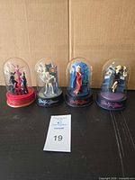 Group shot of all four Marilyn Monroe music-box figurines under glass domes