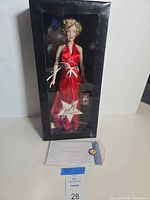 Doll in unopened display box with paperwork in front