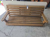 front view of wooden porch swing showing full slatted seat, back and armrests