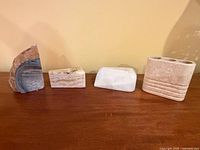 Front view of four polished stone items in a row