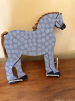 Front view showing painted grey spotted horse with rope mane and tail on stand