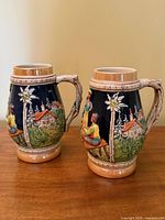 Front view of both matching German beer steins