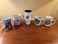 Five mugs lined up showing all graphics and shapes