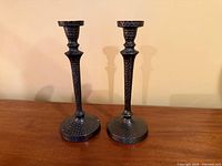 Pair of hammered bronze candlesticks standing upright