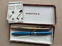 Box open showing blue fountain pen, gold pencil, instruction leaflet