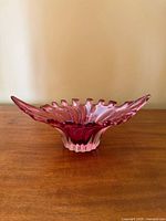 Front view showing cranberry glass bowl with ruffled edge and clear base