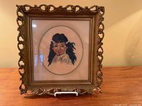 Front view of framed needlepoint portrait in ornate frame