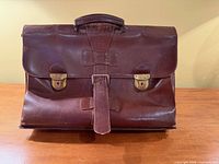 Front view showing flap, handle, strap, and locks