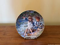 Front of porcelain plate showing children scene and gold rim