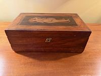 Front and lid view of wooden box showing keyhole and overall condition