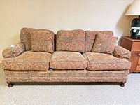 Full front view of sofa with cushions and feet visible