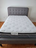 Front view of assembled queen bed showing headboard, mattress, frame