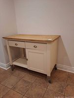 Front and side view of kitchen cart showing drawers, door, casters