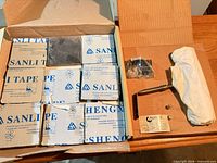 Box with tile sleeves and wrapped picture light showing overall lot contents