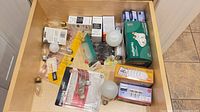 Drawer view showing assorted packaged and loose light bulbs