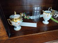 Full lot showing Limoges creamer, sugar bowl, glass tumbler and porcelain flowers