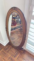 Full view of oval gilt framed mirror