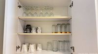 Cabinet shelves showing assorted mugs and glasses