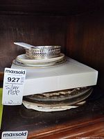 Stack of plates and silver trays with silver coaster and spoon