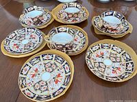 Four cup and saucer sets with three extra saucers on table