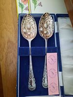 pair of ornate silver-plated serving spoons in presentation case with Town Talk polishing cloth