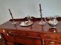 Overview of all silver plate pieces on sideboard