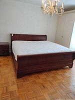 full view of king wood sleigh bed with mattress