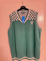 Full front view of green and white Adidas Bogey Boys sweater vest