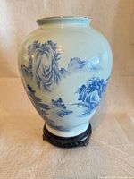 Front view of vase on stand showing hand-painted landscape