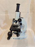 Left-side view of microscope showing objectives, stage and illuminator