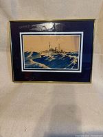 Framed naval ship print with gold frame and blue mat