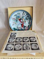 Front view of decorative plate in presentation box with paperwork visible