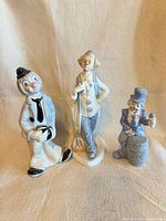 Front view of three porcelain clown figurines
