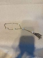 Full view of necklace showing chain, pearls, and tassel