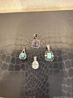 Front view of four gemstone pendants