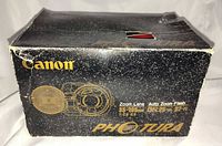 Front of black speckled Canon Photura retail box showing product line art and lens/flash specifications