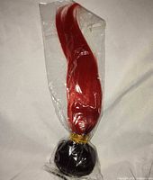 Full view of sealed red hair wig in plastic bag