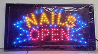 Front view of illuminated "NAILS OPEN" sign