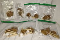 Overall view of seven clear bags containing mini gloves, bats and balls