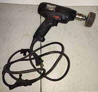 Full view of Craftsman corded drill with flap sanding wheel, coiled damaged cord visible