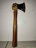 Full view of axe front showing wood handle, leather wrap, steel head