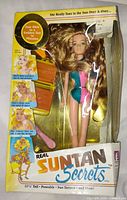 Front of boxed Suntan Secrets Doll showing contents and accessories