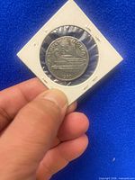 Reverse of coin displaying warship, denomination and date