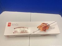 Front of boxed President's Choice stainless steel rotisserie kit showing chicken on spit and product branding