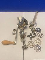 Full set laid out showing body, handle, auger, knife, four plates, stuffing tube, brackets