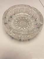 Top view of clear cut crystal ashtray showing starburst pattern and cigarette rests
