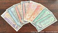 Fan of eight assorted Canadian banknotes showing denominations and colours
